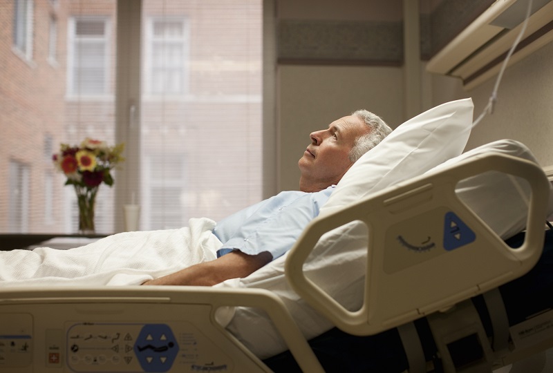 mężczyzna leżący na szpitalnym łóżku